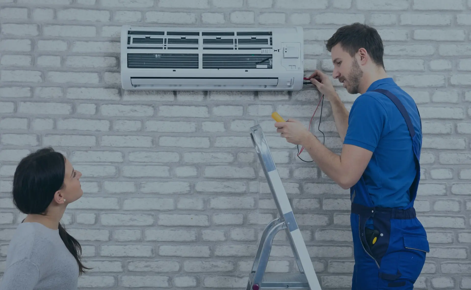Técnico instalando ar-condicionado split em parede de tijolos